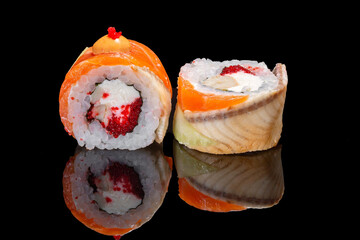 Sushi and rolls on a black mirrored background.