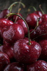 Red cherry berry  with drops of water at rustic ceramic plate at wooden background