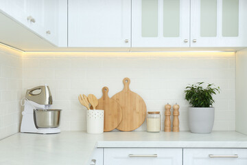 Fototapeta na wymiar Different kitchen items and houseplant on countertop indoors