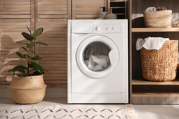 Modern washing machine and shelving unit in laundry room interior