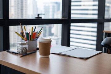 Stationary and blank books on the table, pencil set ,cup of coffee and notebook on wood table , copy space of stationary , working space, space work from home