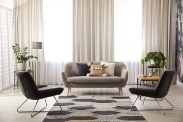Modern living room interior with comfortable sofa and armchairs