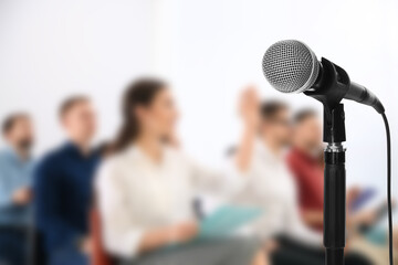 Modern microphone and people at business training indoors, closeup