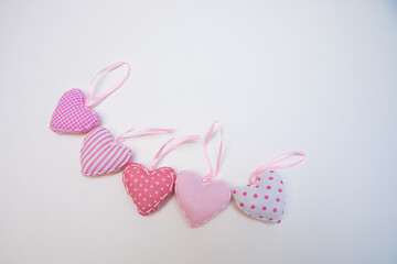 Lovely romantic pink heart-shaped hand sewing crafted decoration on a white background.