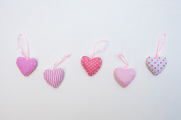 Pink heart-shaped hand crafted decoration on a white background