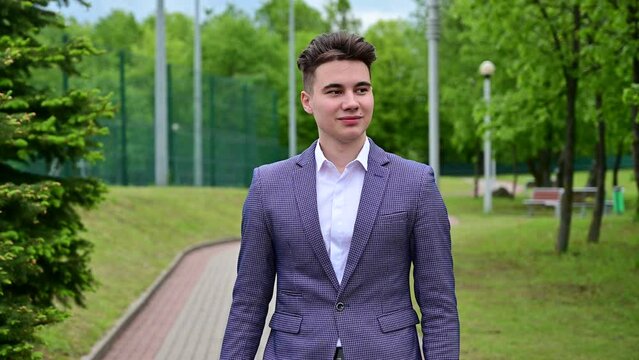 Close up view of calm bearded businessman answering the call and becoming unhappy while sitting in park outdoors