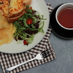 Close up Quesadilla bread on a plate with healthy vegetables and a cup of tea in a glass. Top view