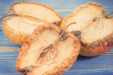 Spoiled apple with mold on boards, unhealthy and disgusting fruit