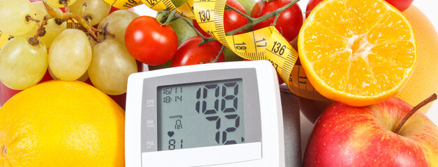 Blood pressure monitor with result of measurement, fruits with vegetables and centimeter