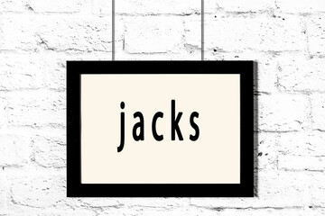 Black frame hanging on white brick wall with inscription jacks © iushakovsky