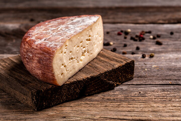 Dark cheese soaked in wine and traditional. on rustic wooden table. Food recipe background. Close up