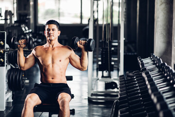 Fototapeta na wymiar Young Man Naked bodybuilder exercising lifting with dumbbell at gym. .Gym equipment and sport concept. Fitness Healthy lifestye and workout at gym concept.