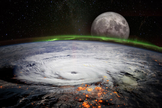 View from space of a giant hurricane over the ocean with full moon rise in background. Elements of this image furnished by NASA.