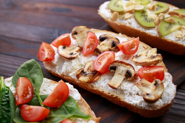 Assorted bruschettas with various toppings. Appetizing healthy homemade snacks, vegetarian toasts with fruits, vegetables and mushrooms. Balanced food, Italian antipasti variation
