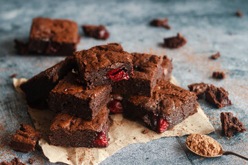 Tasty chocolate brownie with cherry. Pieces of cake on the table