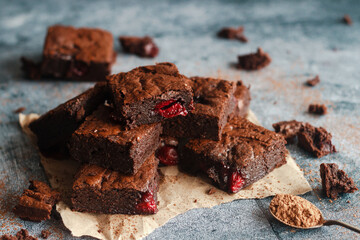 Tasty chocolate brownie with cherry. Pieces of cake on the table