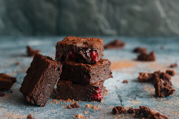 Tasty chocolate brownie with cherry. Pieces of cake on the table