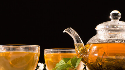 A Cup of green tea and a teapot. Flower tea with fruit slices. Tea ceremony, traditional drink. Afternoon tea, homelike. Flat lay. Oriental, cozy, preparation, heat, tradition, japanese, leafy, herbal