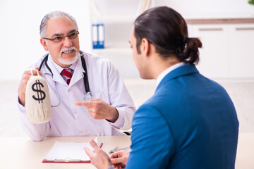 Young businessman meeting with old doctor