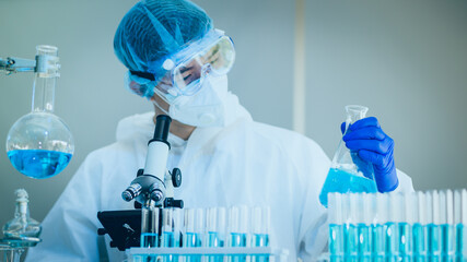 Scientist Working On Coronavirus Vaccine At Lab. 
Abstract of Analyzing covid 19 sample with microscope and holding coronavirus covid 19 blood sample tube in laboratory.