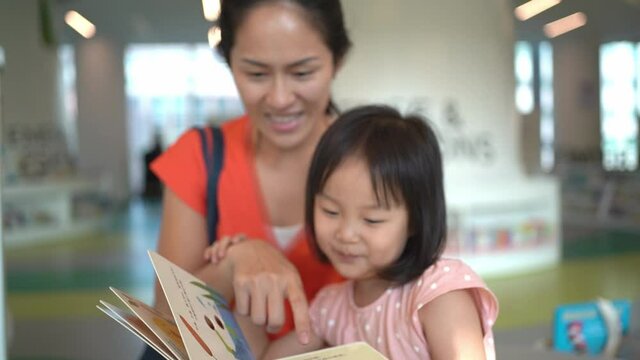 4K Slow Motion of Asian Parent and Child reading at the library