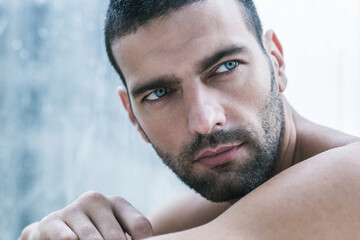 Obraz premium Sexy portrait of topless handsome male model with amazing beautiful blue eyes. Closeup beauty shot.