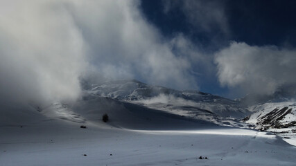 snow covered mountains with fog