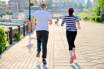 Obraz premium Couple running in city back view, mature man and woman together
