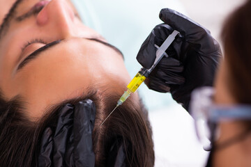 Young man visiting female beautician in hair transplantation con