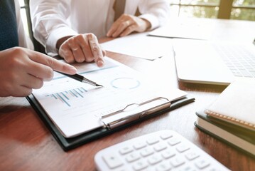 Businessman analyzing investment charts and pressing calculator buttons over documents. Accounting Concept.