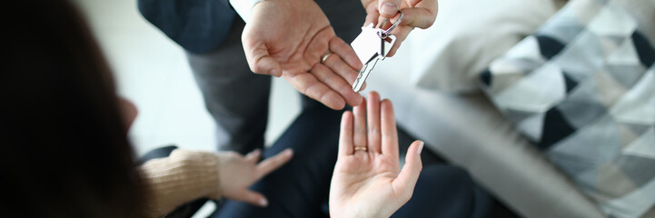 Male businessman hand passes the key to a woman from new housing. Disabled person help concept