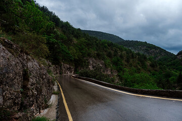 Asphalt road through the mountains forest in rainy season