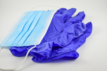 Blue surgical mask and latex gloves with white background