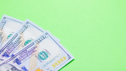One hundred dollars on a green background. American currency. Conceptual background of hundred dollar bills for design. Copy space