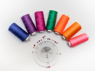 Coil set with colored thread, pincushion on white backgroun