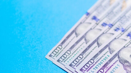One hundred dollars on a blue background. American currency. Conceptual background of hundred dollar bills for design. Copy space