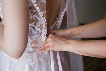 Obraz na płótnie Canvas hand of the bride on a wedding dress
