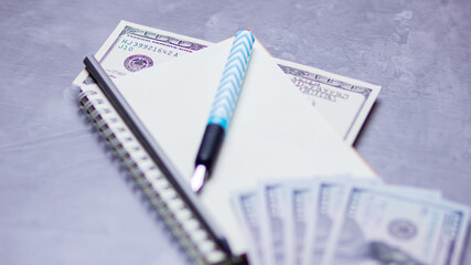 Financier workplace. One hundred dollars. American currency. Notebook and hundred dollar bills on a gray background. Financial investment. Copy space