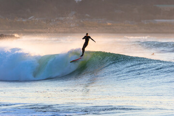 Surfing in Japan, man riding a surfboard in the pacific ocean near Tokyo