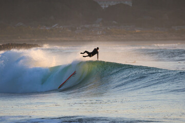 Surfing in Japan, man riding a surfboard in the pacific ocean near Tokyo