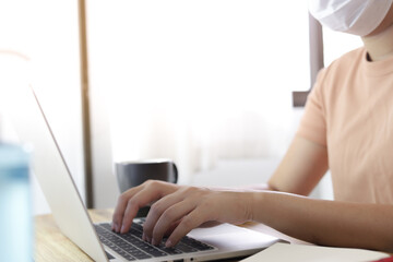 Woman working from home. wearing protective mask. COVID-19 Pandemic Coronavirus home isolation auto quarantine wearing face mask protective for spreading of disease virus SARS-CoV-2. Working from home