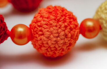 Slingobusy. Wooden ball tied with orange yarn close-up on white background
