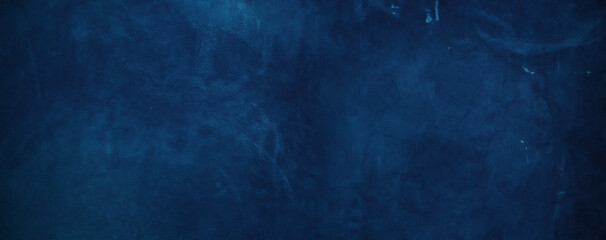 The background of the stucco wall is dark blue. wall texture rough abstract decorated in blue.