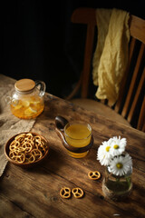 Cookies, fruit tea on a wooden table, a chair in the background.