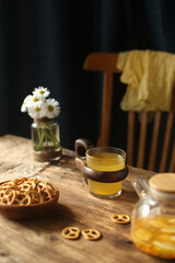 Cookies, fruit tea on a wooden table, a chair in the background.