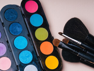 makeup brushes and brightly coloured palette with shades for painting eyes