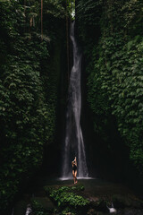 young woman backpacker looking at the waterfall in jungles. Ecotourism concept image travel girl