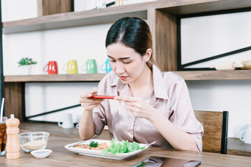 Asian woman taking pictures of food on the table