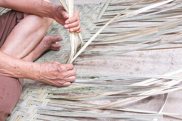 Weaving reed mat by old asian woman hand , handmade thai style