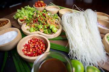 Raw rice flour in a wooden bowl with spices On a dark wood with natural light, focusing on the top...